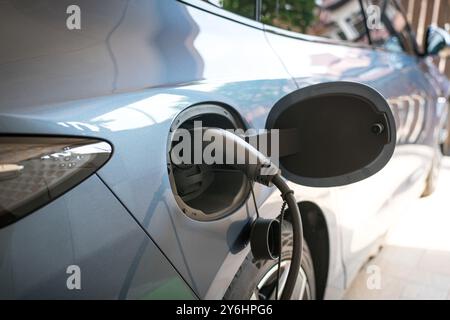 Elektroauto, das zu Hause aufgeladen wird, von einer installierten Wallbox. Stockfoto