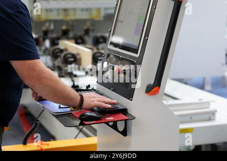 Der Bediener arbeitet am Bedienfeld der CAD/CAM-Holzbearbeitungsmaschine (Computer-aided Design and Computer-aided Manufacturing). Selektiver Fokus. Stockfoto