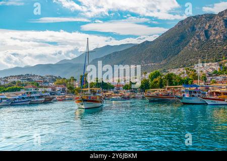 Kas, Antalya, Türkei - 7. August 2024: Tägliche Bootstouren vor Anker am Meer und warten auf Passagiere. Kas Hafen und Kas Stadt und Berg in t Stockfoto