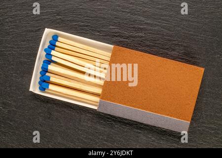 Hölzerne Streichhölzer, um ein Feuer auf Schieferstein zu entfachen, Makro, Draufsicht. Stockfoto