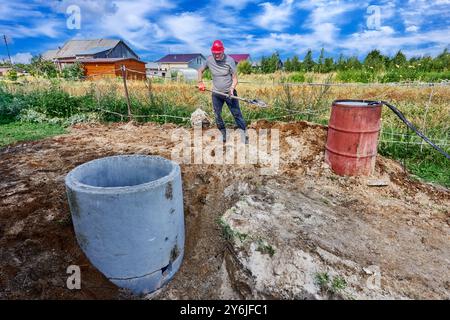 Aufbau eines autonomen Kanalisationssystems für Landhäuser, Abfallentsorgung oder Klärgrube aus Stahlbetonringen. Stockfoto