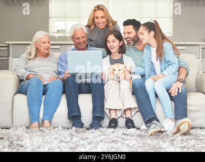 Große Familie, glücklich und entspannen Sie mit Laptop auf Sofa für Internet, Verbindung und Filme zusammen. Eltern, Großeltern und Kinder mit Hund Stockfoto