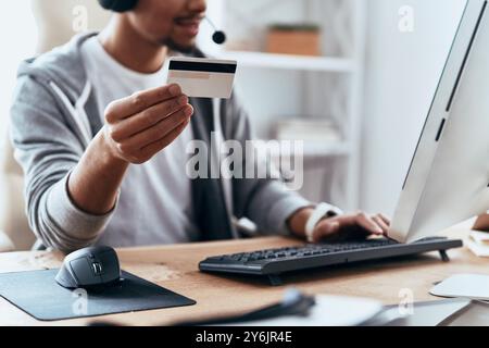 Bestellen Sie etwas online. Nahaufnahme eines jungen Mannes in lässiger Kleidung, der online kauft, während er Zeit zu Hause verbringt Stockfoto