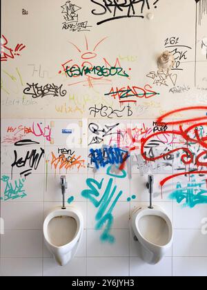 Graffiti im Urinal eines Mannes, öffentliche Toilette Stockfoto