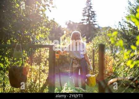 Eine ältere Frau, die an einem sonnigen Tag an ihrem Schreck arbeitet Stockfoto