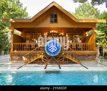 Wunderschöne Holzvilla mit Pool, umgeben von üppig grünen Bäumen, ideal für Urlaub und Entspannung Stockfoto