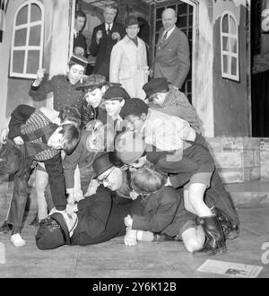 London : der Schauspieler Stanley Platts ( Polizist ) wird von den Kinderdarstellern " The Gang " in " Emil and the Detectives " gewürdigt , die heute in der Probe im her Majestys Theatre im Londoner Haymarket gezeigt werden und eine Staffel von Matinees Only eröffnen . Der andere Erwachsene, der von den Jugendlichen zerquetscht wird , ist der Bowler mit Hüten und Schauspiel " Mr. Grundle " , dargestellt von Norman Scace . Dezember 1962 Stockfoto