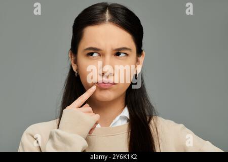 Eine elegant gekleidete junge Frau zeigt ihre Gefühle mit einer nachdenklichen Geste. Stockfoto