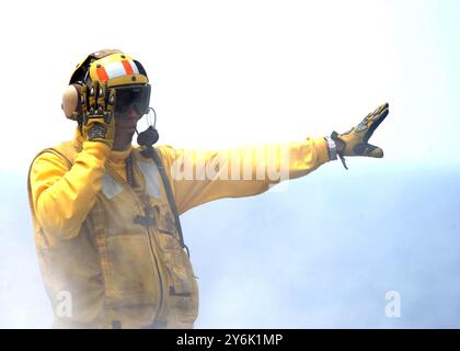 070709-N-6854D-006 Atlantischer Ozean (9. Juli 2007) – Ein Flugzeugdirektor signalisiert eine F/A-18C Hornet, bevor er vom Flugdeck der Nimitz-cl startet Stockfoto