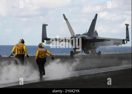 Seeleute an Bord des Flugzeugträgers USS Dwight D. Eisenhower überqueren das Flugdeck, um sich auf den Start eines Flugzeugs vorzubereiten. Dwight D. Eisenhower ist unterwegs Stockfoto