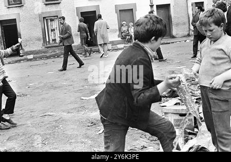 Londonderry , Nordirland . Die Schlacht von Bogside geht weiter und jetzt spielen sogar die Kinder dieser Stadt eine Rolle im Kampf gegen die Polizei... Während ein Junge (links) eine gerade gebaute Benzinbombe in der Hand hält, bereiten zwei andere Dots vor, um mehr zu machen. Das war nur eine der vielen verstörenden Szenen in Derry heute. Die Gewalt der letzten Tage hat ähnliche Vorfälle in der Hauptstadt Belfast und anderen Großstädten in Ulster am 14. August 1969 ausgelöst Stockfoto