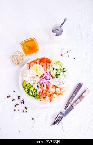 Mittagessen - Reis, Garnelen, Avocado auf einem Teller auf hellem Hintergrund, Blick von oben Stockfoto