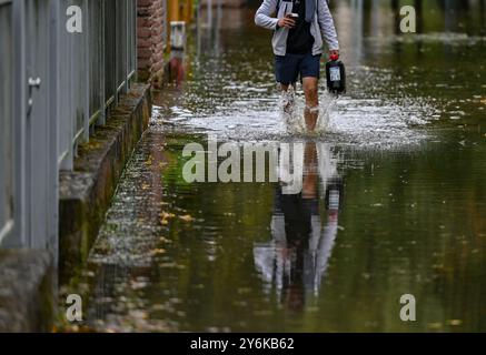 26. September 2024, Brandenburg, Frankfurt (oder): Ein Bewohner des von der oder überfluteten Buschmühlenweges in Frankfurt (oder) geht durch das Wasser. In einigen Gemeinden im Hochwassergebiet entlang der oder sind die Wasserstände seit einigen Stunden zurückgegangen. Angesichts der Prognosen für die weiter nördlich gelegene Stadt Frankfurt (oder) dürfte auch der aktuelle maximale Wasserstand dort in wenigen Stunden überwunden sein. Foto: Patrick Pleul/dpa Stockfoto