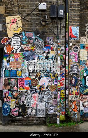 Eine Wand mit Weizenpaste Street Art, Fashion Street, Whitechapel, London, Großbritannien. September 2024 Stockfoto