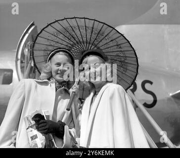 Gloria Ward & Eileen McDonnell - Beauties Under a Parasol - Skater mit der 140-köpfigen Besetzung der Rollschuhshow Skating Vanitys von 1951, die für eine sechswöchige Saison im Empire Pool in Wembley beginnt. Glorias Beine allein sind für 000 Pfund versichert. Foto vom 11. Juni 1951 ©TopFoto Stockfoto