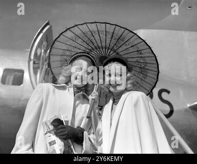 Gloria Ward & Eileen McDonnell - Beauties Under a Parasol - Skater mit der 140-köpfigen Besetzung der Rollschuhshow Skating Vanitys von 1951, die für eine sechswöchige Saison im Empire Pool in Wembley beginnt. Glorias Beine allein sind für 000 Pfund versichert. Foto vom 11. Juni 1951 ©TopFoto Stockfoto