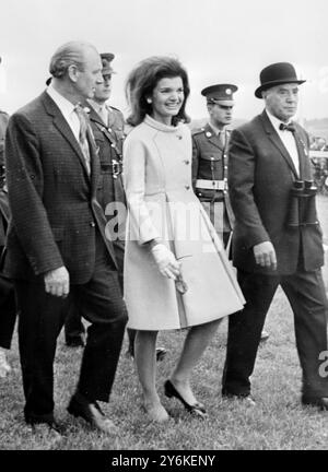 Dublin, Irland: John F. Kennedy wird vom Premierminister Jack Lynch (links) und Colonel P. Mulcahy, Steward des Irish Turf Club, zum Paradering in Curragh begleitet. Mrs. Kennedy trug einen hellgrünen Mantel, keinen Hut, schwarze Pumps und eine Handtasche. 3. Juli 1967 Stockfoto