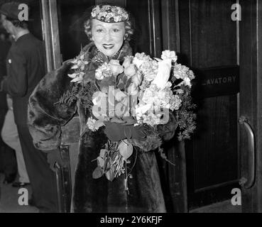 In Waterloo, auf der Abreise nach Südafrika. Miss Luella Paikin, Prima Donna von Carl Rose Company, und Herr Kingsley Lark, Produzent, bei der Abreise zu einer Krönungsreise durch Südafrika am 16. April 1937. © TopFoto Stockfoto