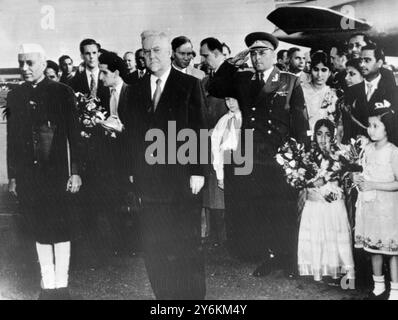 Moskau: Pandit Jawarharlal Nehru (links), Premierminister von Indien, und Marschall Nikolai Bulganin (Mitte), Premierminister der Sowjetunion, stehen im Lufthafen in Moskau, während Militärbands nach Nehrus Ankunft aus Prag die indische und sowjetische Nationalhymne spielen. 8. Juni 1955 Stockfoto