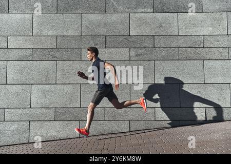 Gesunde Gewohnheiten. In voller Länge eines jungen Mannes in Sportbekleidung, der beim Training draußen läuft Stockfoto