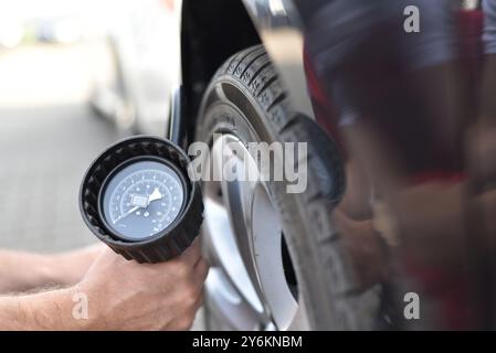 Automechaniker prüft den Luftdruck eines Reifens in der Garage Stockfoto