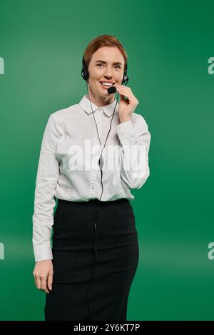 Eine selbstbewusste Frau in einem strahlend weißen Hemd spricht über ein Headset und ist bereit, Anrufern zu helfen. Stockfoto