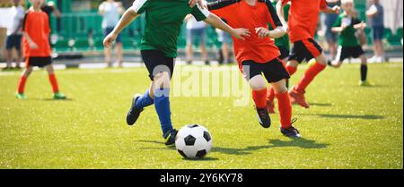 Junge Jungs spielen Fußball. Training und Fußballspiel zwischen Jugendfußballmannschaften. Junior-Wettkampf zwischen Spielern, die laufen Stockfoto