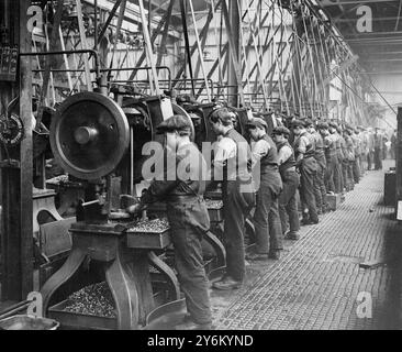 Ostern in Woolwich im Südosten Londons. Munition funktioniert über die Feiertage. Jungs arbeiten an den Maschinen, die die Blei-Kerne für Kugeln schneiden. 29. März 1918 Stockfoto