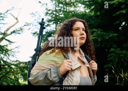 Eine selbstbewusste Frau in Übergröße genießt einen friedlichen Moment in einem üppigen Wald, umgeben von Natur. Stockfoto