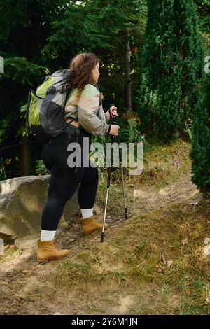 Eine Frau in Übergröße erkundet fröhlich einen lebendigen Wald und umrahmt die Schönheit der Natur. Stockfoto