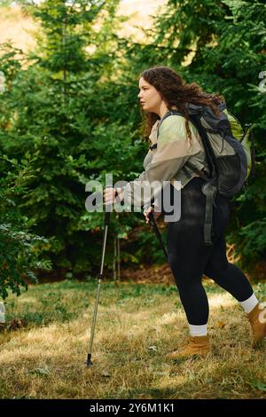 Eine Frau in Übergröße genießt eine friedliche Wanderung, umgeben von lebhaftem Grün und natürlicher Ruhe. Stockfoto