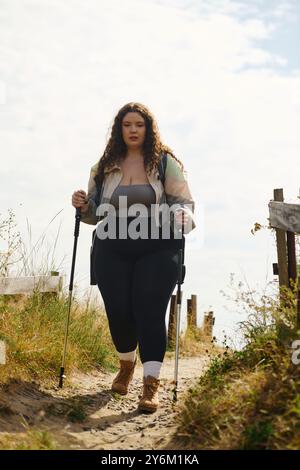 Eine schöne Frau in Übergröße erkundet einen friedlichen Pfad in der Natur und genießt ihr Abenteuer. Stockfoto