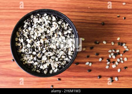 Split Black Linse auch bekannt als Black Gram, Black urad Dal, Vigna Mungo, urad Bean auf braunem hölzernem Hintergrund Stockfoto