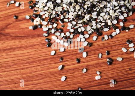 Split Black Linse auch bekannt als Black Gram, Black urad Dal, Vigna Mungo, urad Bean auf braunem hölzernem Hintergrund Stockfoto