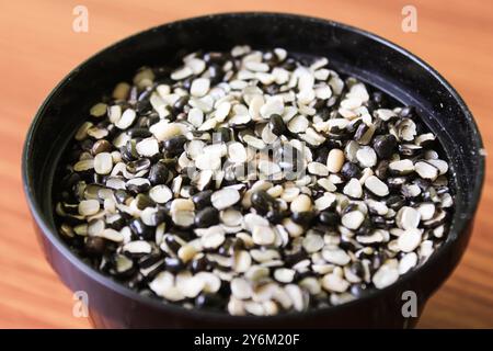 Split Black Linse auch bekannt als Black Gram, Black urad Dal, Vigna Mungo, urad Bean auf braunem hölzernem Hintergrund Stockfoto