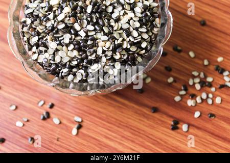 Split Black Linse auch bekannt als Black Gram, Black urad Dal, Vigna Mungo, urad Bean auf braunem hölzernem Hintergrund Stockfoto