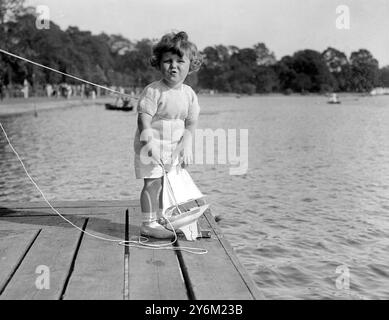 Kleiner Tommy Sopwith ( 22 Monate alter Sohn von Herrn und Frau T O M Sopwith ) auf wen die Aufmerksamkeit der ganzen Welt gerichtet ist, während sie Amerikas Einfluss auf den America's Cup herausfordern ( die berühmteste Yachtinhg-Trophäe der Welt ) verbrachte Sonntagnachmittag auf der Serpentine im Hyde Park und segelte seine Modellyacht die er Endeavour genannt hat - er hofft, ein Segler wie sein Daddy zu sein - Foto zeigt den kleinen Tommy Sopwith ängstlich, wie er sein Craft-Rennen beobachtet am Serpentine Lake im Hyde Park in London, 16. September 1934 Stockfoto