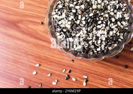 Split Black Linse auch bekannt als Black Gram, Black urad Dal, Vigna Mungo, urad Bean auf braunem hölzernem Hintergrund Stockfoto