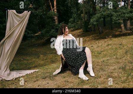 Eine freudige Frau in Übergröße entspannt sich in einem üppigen grünen Feld, umgeben von ruhiger Natur. Stockfoto