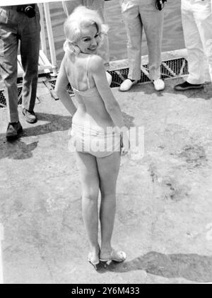 Cannes, Frankreich: Als sie für eine Badeanzug-Show am Strand auftrat, wird die formschöne amerikanische Schauspielerin Carroll Baker sofort von Pressefotografen umgeben. 31. Mai 1965 Stockfoto