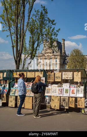 Frankreich, Paris, 75, Quai Voltaire, 7. ARRT, 2 junge Touristen vor den Bücherkartons, Frühjahr 2023. Stockfoto