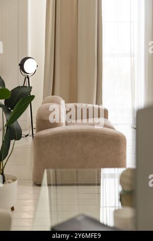 Luxuriöses Wohnzimmer mit weißem Holzlaminat-Parkettboden, beigefarbenem Sofa, Couchtisch, Innenpflanze im Sonnenlicht vom Fenster aus der Innenseite. Inter Stockfoto