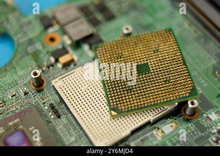 Nahaufnahme einer Computer-CPU auf einem grünen Motherboard, die Technologie und digitale Konzepte hervorhebt. Stockfoto