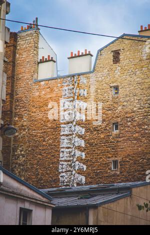 Frankreich, Paris. Street Art, Spine an einer Backsteinmauer auf der Rückseite eines Gebäudes Stockfoto