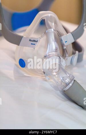 Stillleben einer Maske auf einem Bett, um Schlafapnoe zu behandeln Stockfoto