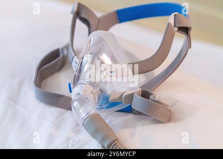 Stillleben einer Maske auf einem Bett, um Schlafapnoe zu behandeln Stockfoto