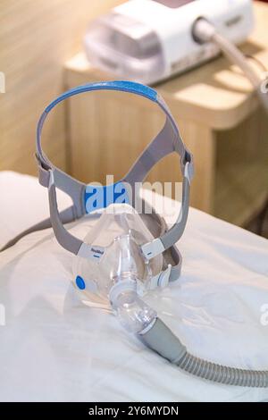 Stillleben einer Maske auf einem Bett, um Schlafapnoe zu behandeln Stockfoto