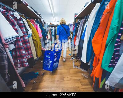 Blonde Frau mit einem Einkaufswagen in einem Noz-Laden Stockfoto