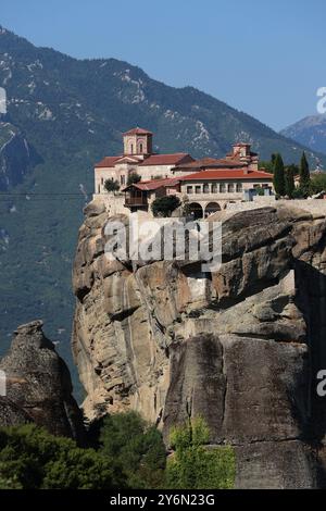 Ein malerischer Blick auf das Kloster der Heiligen Dreifaltigkeit auf einer Klippe mit bergiger Kulisse in Meteora, Griechenland. Stockfoto