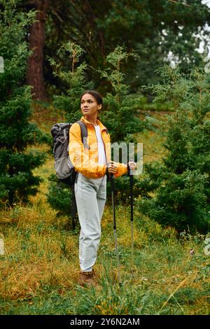 Eine junge Afroamerikanerin wandert gern in einem bunten Herbstwald, umgeben von üppigem Grün. Stockfoto